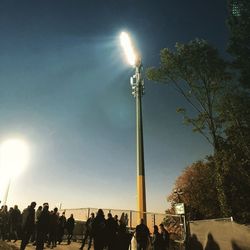 Low angle view of people on street against sky at night