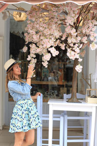 Low angle view of woman standing by flowering plants