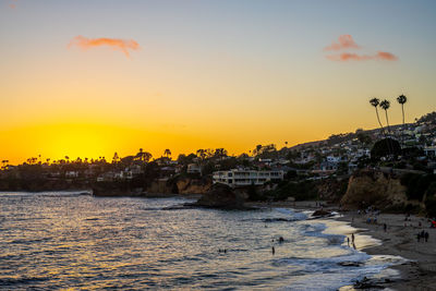 Scenic view of sea and buildings against sky during sunset