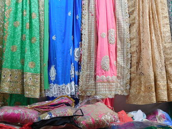 Close-up of multi colored clothes hanging on fabric