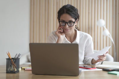 Young woman using laptop at table