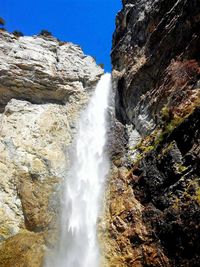 Low angle view of waterfall against sky