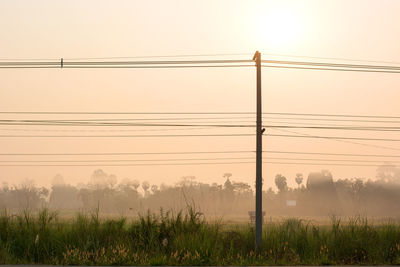 Electricity pylon on field against sky