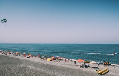 People on beach against clear sky