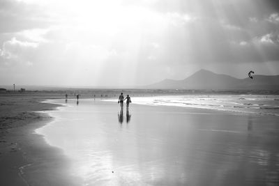 People on beach against sky