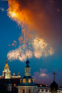 Firework display against sky at night