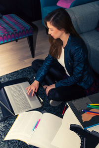 High angle view of woman using laptop while sitting at home