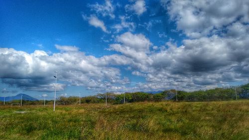 Scenic view of field against cloudy sky