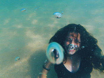 Close-up portrait of young woman underwater