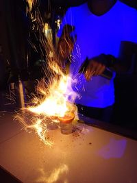 Midsection of woman with illuminated lights at night