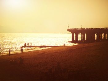 Silhouette of pier on beach