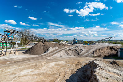 Heaps of gravel and crushed on blue sky at an industrial cement plant.