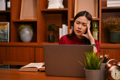 Young woman using laptop at table