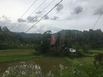 Overhead cable car over field against sky