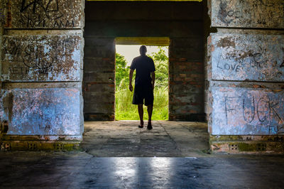 Rear view of man walking in corridor