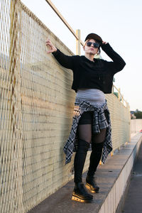 Full length of young woman standing on railing