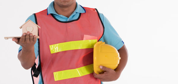 Midsection of man holding umbrella against white background