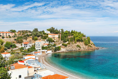 Scenic view of sea by buildings against sky