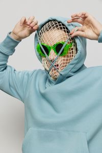 Playful man wearing mesh bag pulling hood strings