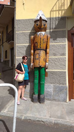 Full length portrait of girl standing against built structure