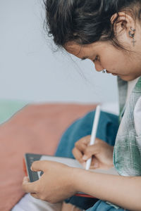 Asian plus-size freelancer working on project, portrayt ease, creative freedom of working from home