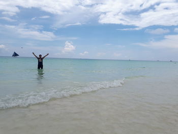 Man standing in sea against sky