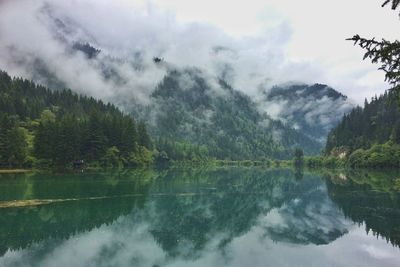 Scenic view of lake by trees against sky