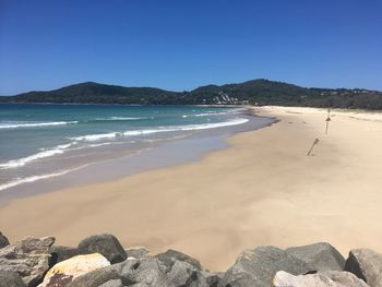Scenic view of beach against clear blue sky