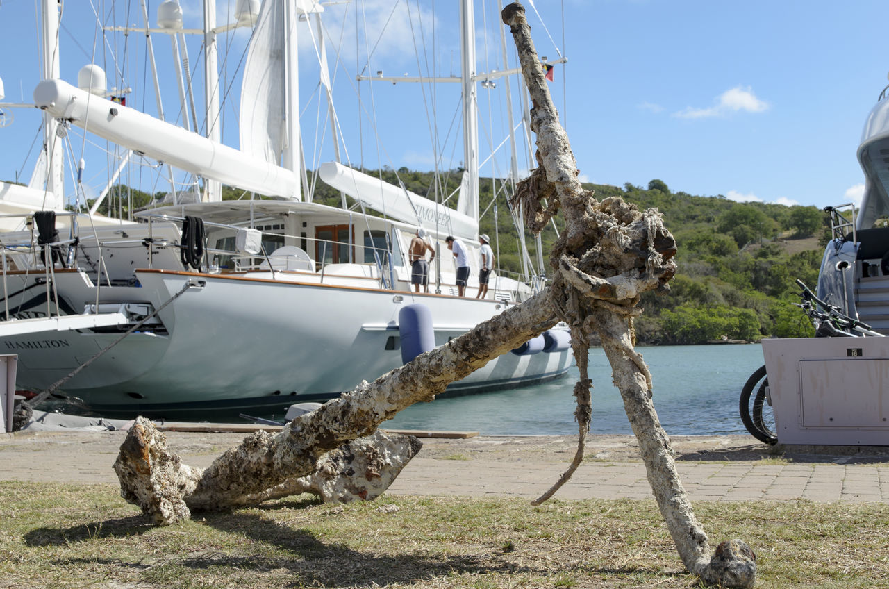 transportation, mode of transport, sky, nautical vessel, water, travel, sunlight, day, sea, boat, incidental people, men, moored, outdoors, built structure, harbor, shadow, nature, blue