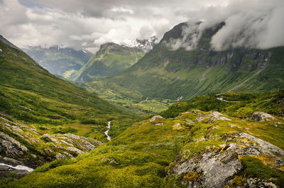 Scenic view of valley and mountains against sky