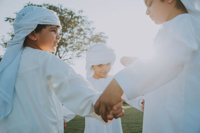 Cute brothers wearing traditional clothing playing in park