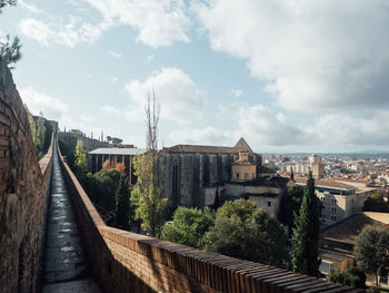 Bridge amidst buildings in city against sky