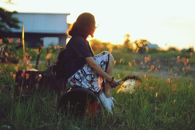 Woman standing on field at sunset