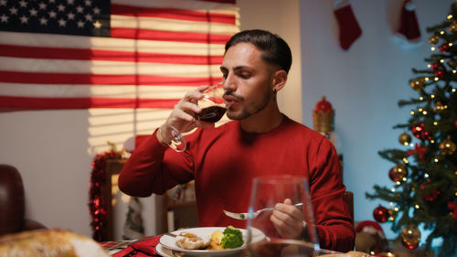 Portrait of young woman having food at home