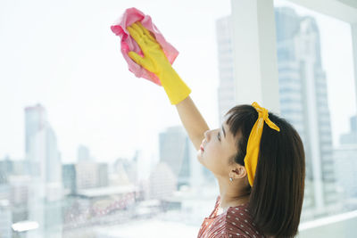 Portrait of young woman standing against cityscape