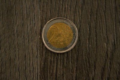 Close-up of two euro coin on wooden table