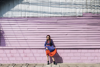 Portrait of woman standing against wall