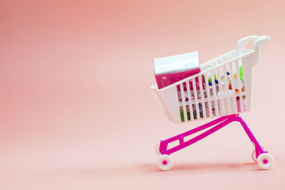 Close-up of miniature shopping cart against white background