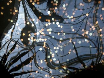 Defocused illuminated lights reflecting on fountain water