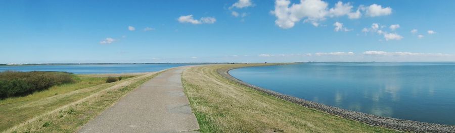 Panoramic view of road by sea against sky