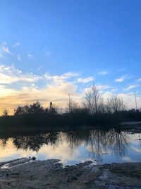 Scenic view of lake against sky at sunset