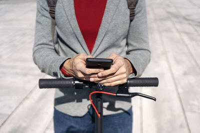 Midsection of man using mobile phone