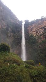 Scenic view of waterfall against sky