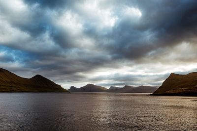 Scenic view of lake by mountains against sky