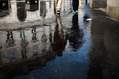 Low section of people walking on wet street during rainy season