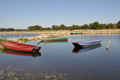 Boat moored in lake against sky