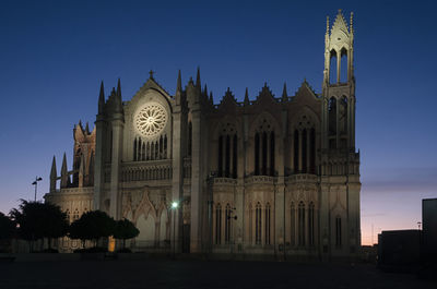 Low angle view of illuminated church against blue sky