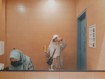 Rear view of 2 friends washing their hand