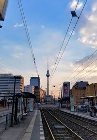 Railroad tracks against sky in city