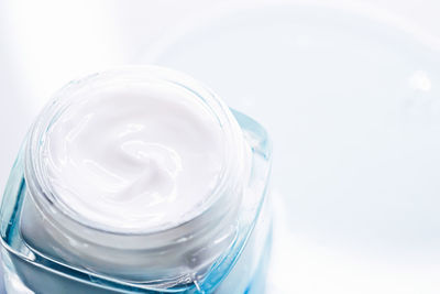 Close-up of glass of jar over white background